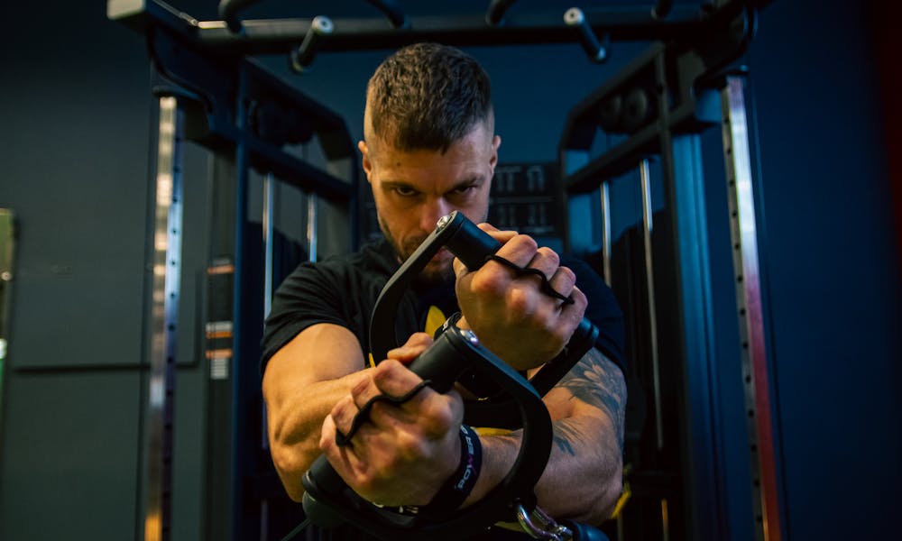 A man doing pull ups in a gym .pexels