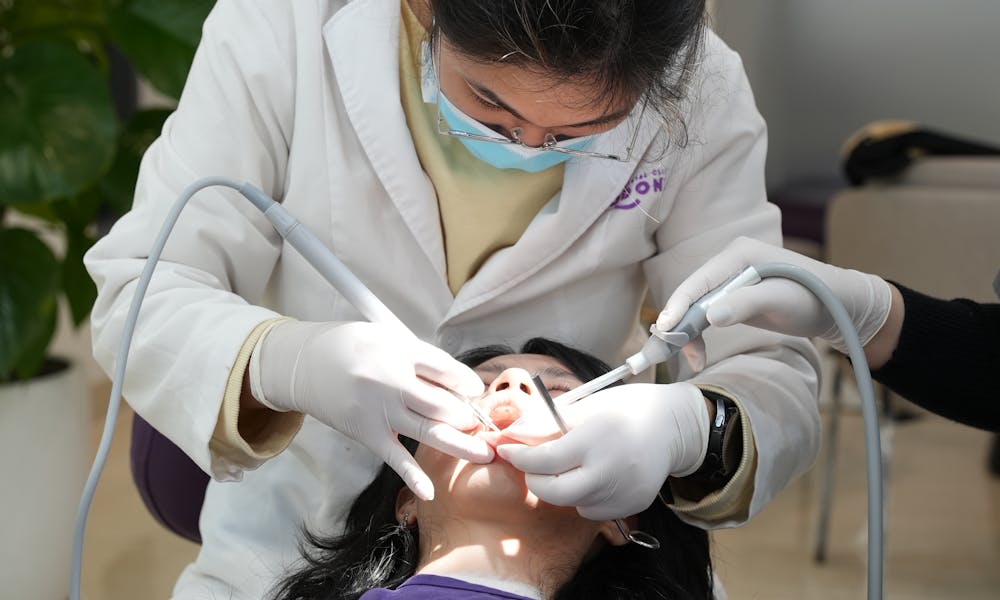 A woman getting her teeth cleaned by a dentist .pexels