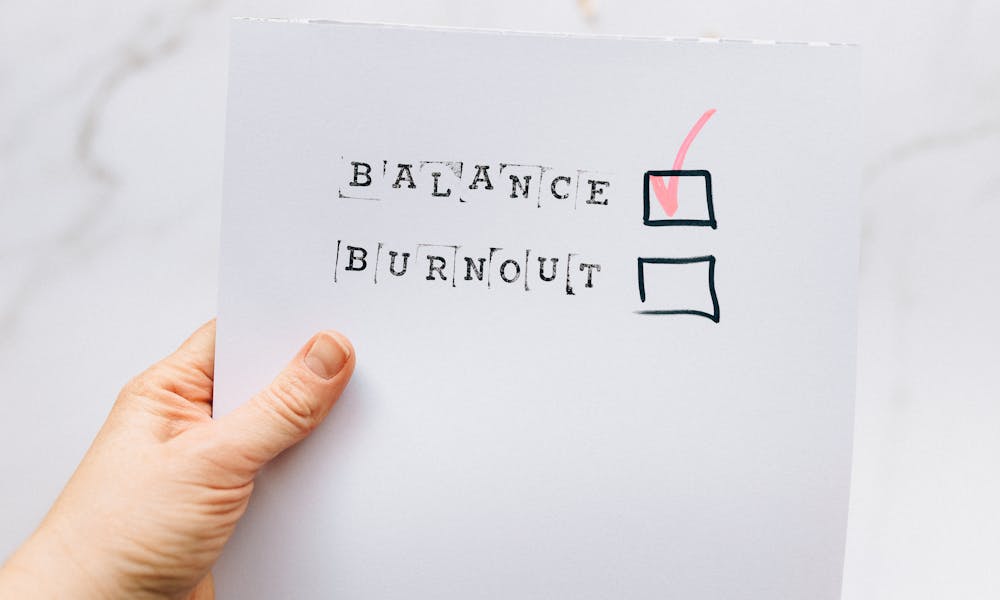 A hand holding a checklist highlighting the choice of balance over burnout, emphasizing mental health awareness. .pexels