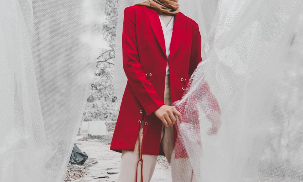 Stylish woman in hijab and red blazer posing gracefully in an outdoor setting in West Java. .pexels