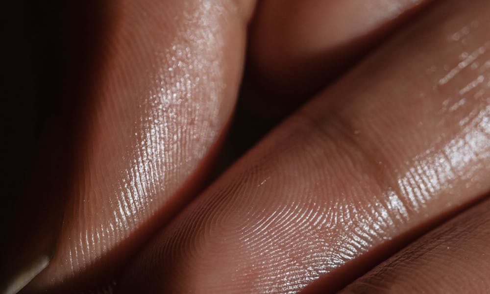 Close-up shot of fingers with smooth skin, showing delicate texture and light reflection. .pexels