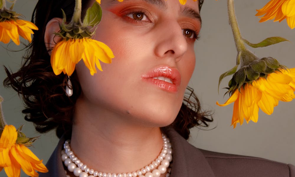 Stylized portrait of a woman with sunflowers, showcasing fashion and natural beauty. .pexels