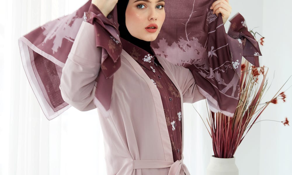 Stylish woman in a pink patterned hijab posing during an indoor fashion photoshoot. .pexels