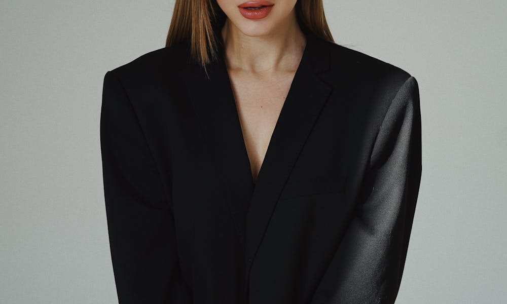 Elegant portrait of a woman sitting confidently in a studio. Modern and fashionable. .pexels