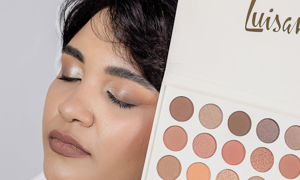 Elegant portrait of a woman showcasing a large eyeshadow palette. .pexels