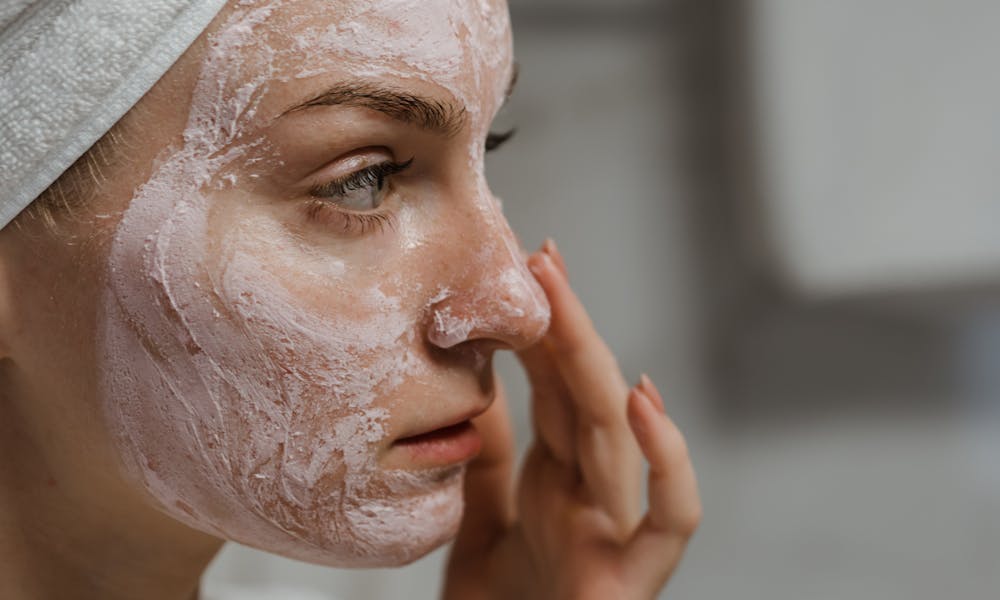 Close-up of a woman applying facial cream as part of her skincare routine, enhancing skin health. .pexels