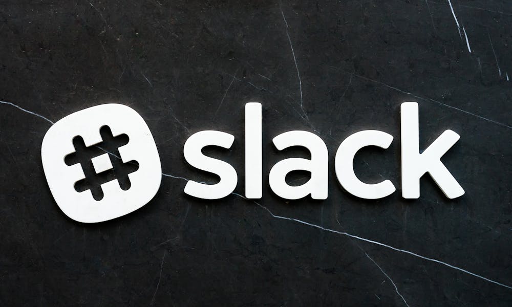 Close-up of Slack logo with hashtag symbol on a dark textured background, emphasizing digital communication. .pexels