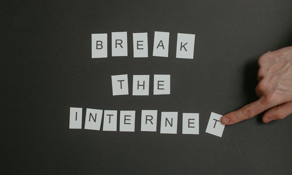 Textual phrase 'Break the Internet' arranged on a black background with a pointing hand. .pexels