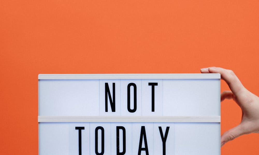 A motivational sign reading 'NOT TODAY #COVID19' against a bright orange background, symbolizing resilience. .pexels