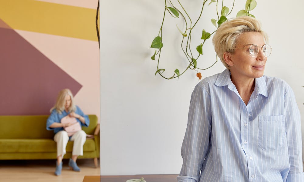 Casual woman leaning on table in modern interior, soft colors create a relaxed atmosphere. .pexels