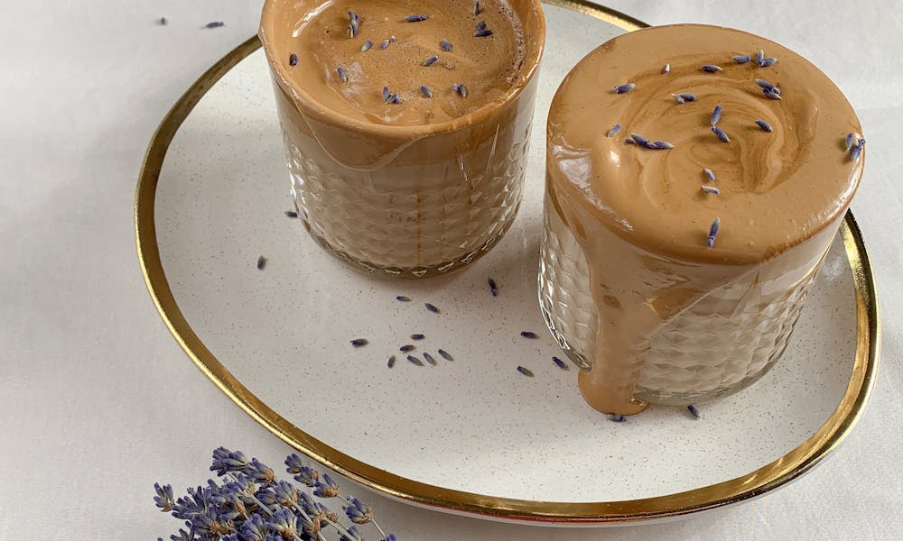 Creamy dalgona coffee topped with lavender on a gentle white background. .pexels