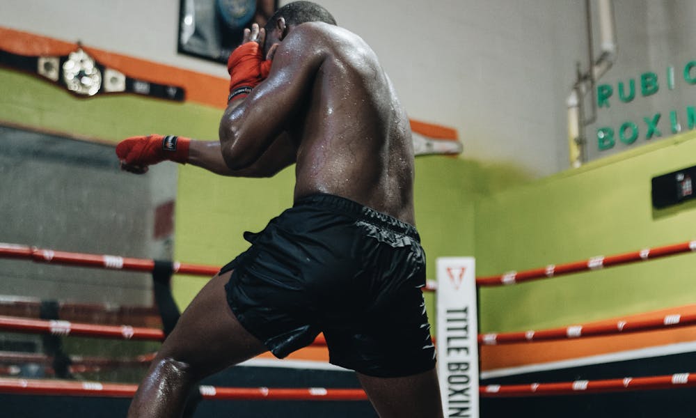 An athlete training hard in a boxing ring inside a gym. .pexels