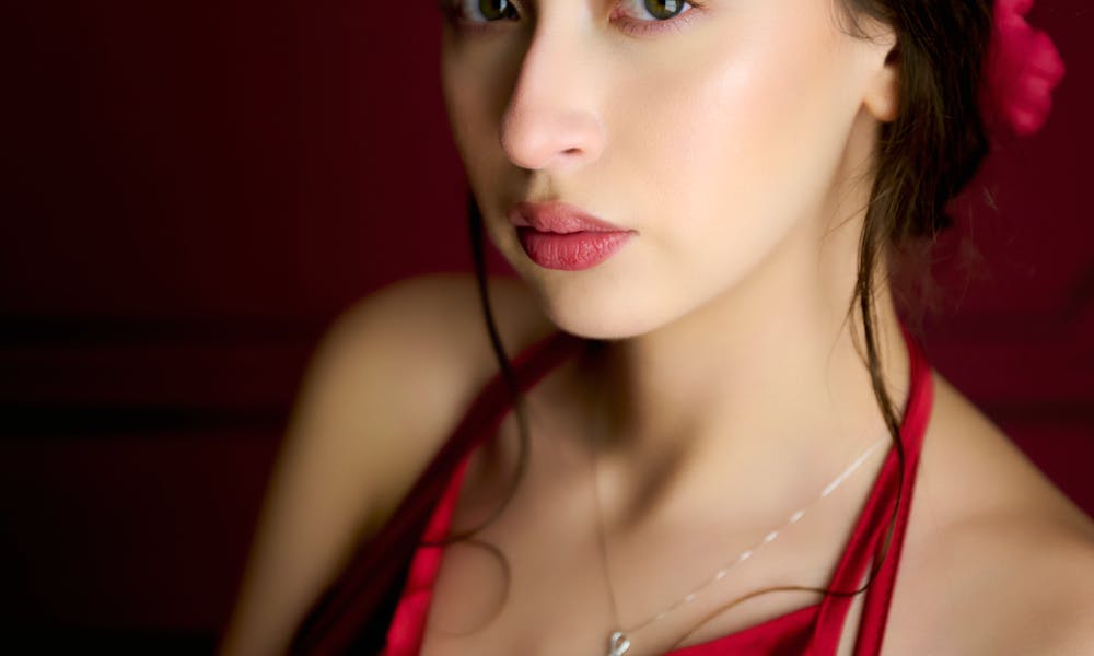 Stunning portrait of a woman in a red dress with a captivating gaze. .pexels