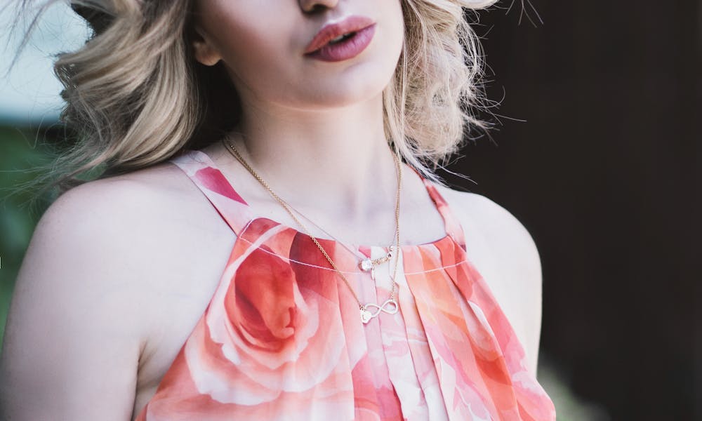 Stylish outdoor portrait of a woman in a floral dress with elegant makeup .pexels