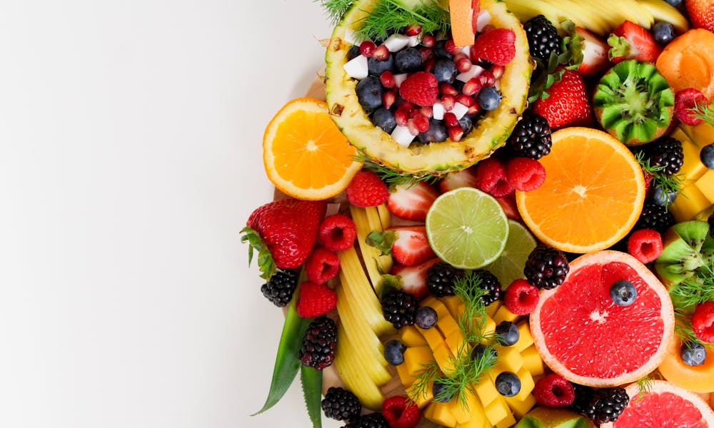 Colorful flat lay of assorted tropical fruits including pineapple, berries, and citrus. .pexels