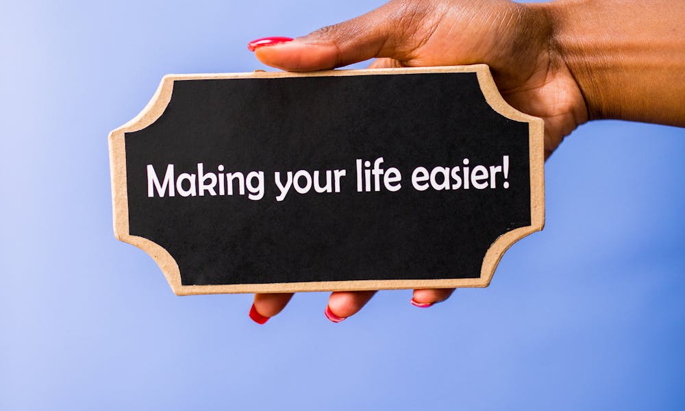 A hand holding a chalkboard with an inspirational quote against a blue background. .pexels