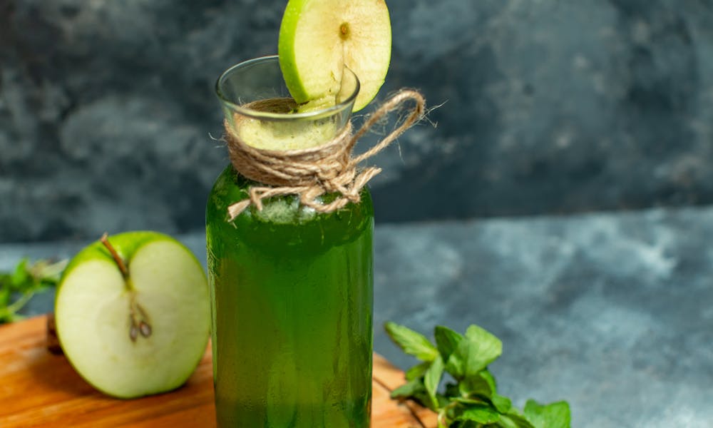 Green apple juice with mint leaves and cinnamon sticks on wooden board. .pexels