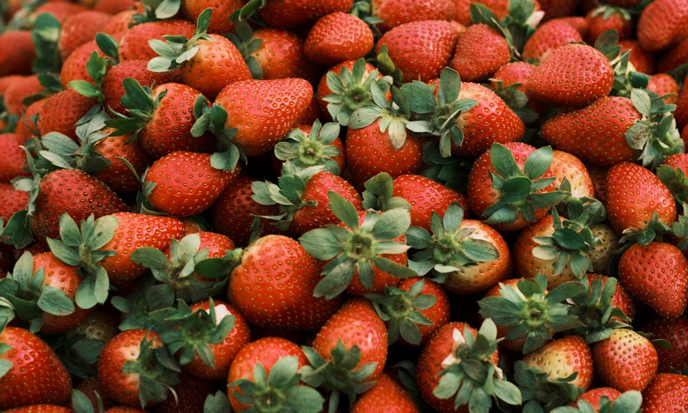 Close-up of ripe red strawberries with green leaves, perfect for healthy eating or recipes. .pexels