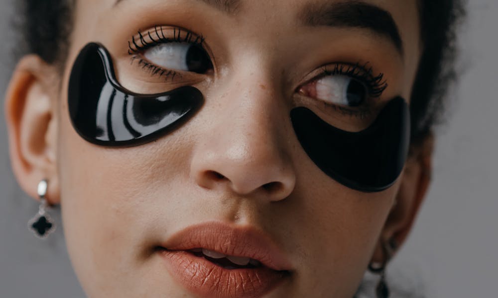 Close-up portrait of a woman with under-eye skincare patches, showcasing beauty routines. .pexels