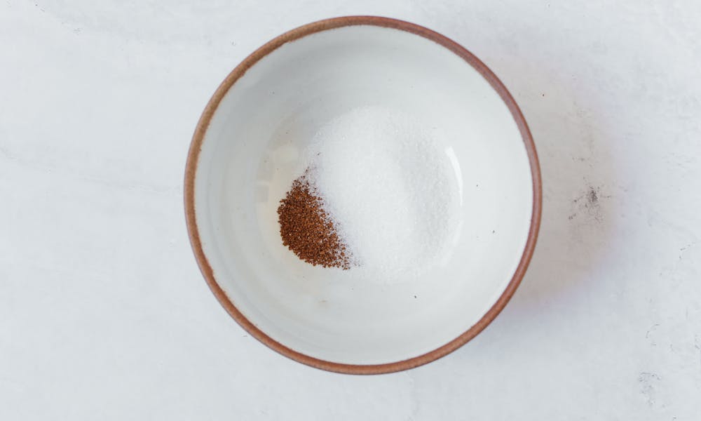 A minimalist shot of sugar and coffee in a ceramic bowl for dalgona coffee preparation. .pexels