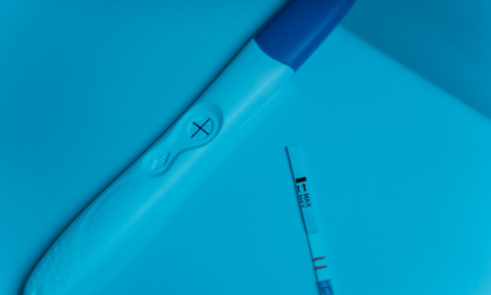 Positive pregnancy test on blue surface, symbolizing new beginnings and family planning. .pexels