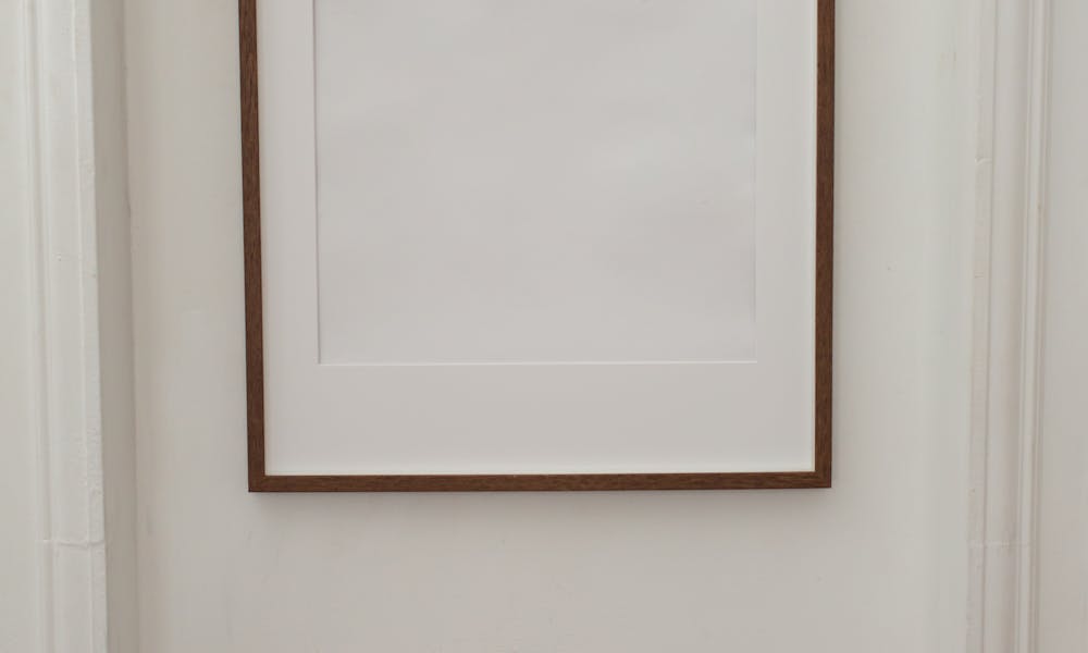 White minimal empty frame hanging on wall of contemporary flat with simple walls .pexels