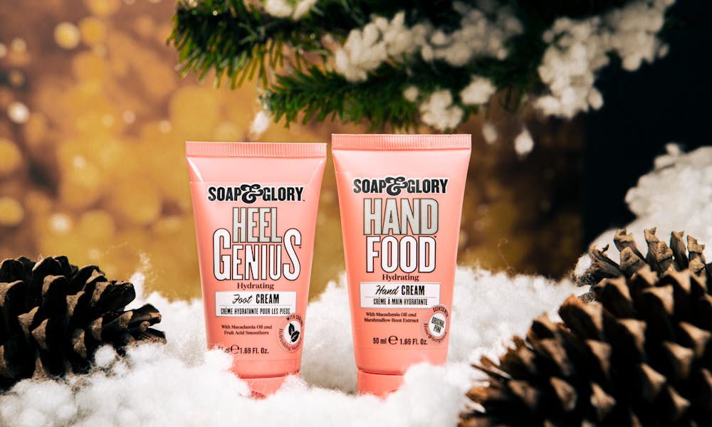 Soap & Glory creams amidst pine cones and snow create a festive look. .pexels